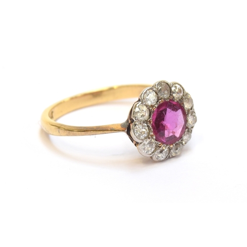 12 - An early 20th century 18ct gold and platinum mounted diamond and ruby floral cluster ring, the ruby ... 