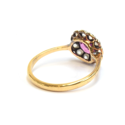 12 - An early 20th century 18ct gold and platinum mounted diamond and ruby floral cluster ring, the ruby ... 