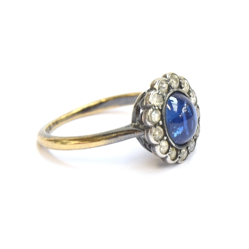 24 - An early 20th century 18ct gold, sapphire cabochon and diamond cluster ring, the sapphire measuring ... 