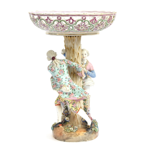 A 19th century Meissen porcelain figural centrepiece, having a pierced basket painted with floral sprays supported on column in the shape of a tree trunk surrounded by a courting couple, underglaze blue crossed sword mark to base, 43.5cm high, 30.5cm diameter
