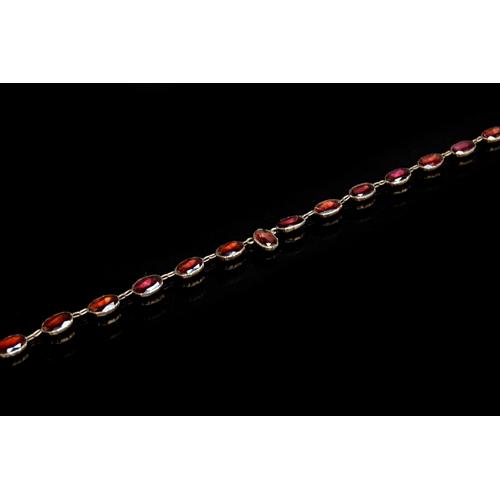 35 - A late 19th century gold mounted flat cut garnet riviere necklace, each of the foiled garnets 1cm lo... 