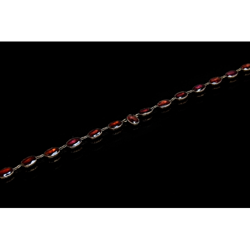 35 - A late 19th century gold mounted flat cut garnet riviere necklace, each of the foiled garnets 1cm lo... 