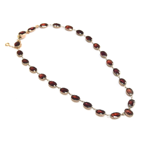 35 - A late 19th century gold mounted flat cut garnet riviere necklace, each of the foiled garnets 1cm lo... 