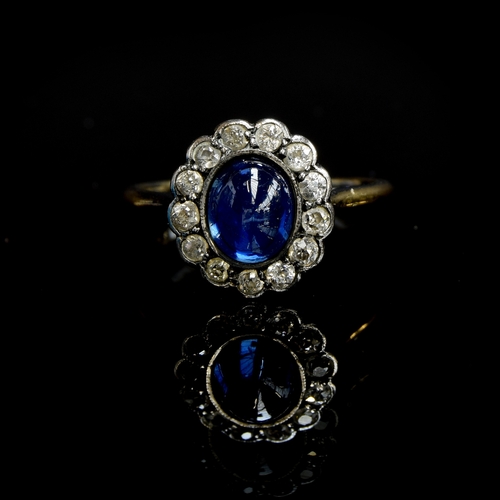 24 - An early 20th century 18ct gold, sapphire cabochon and diamond cluster ring, the sapphire measuring ... 