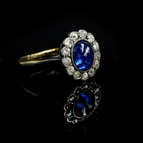 24 - An early 20th century 18ct gold, sapphire cabochon and diamond cluster ring, the sapphire measuring ... 