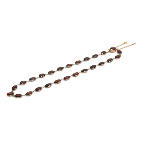 35 - A late 19th century gold mounted flat cut garnet riviere necklace, each of the foiled garnets 1cm lo... 