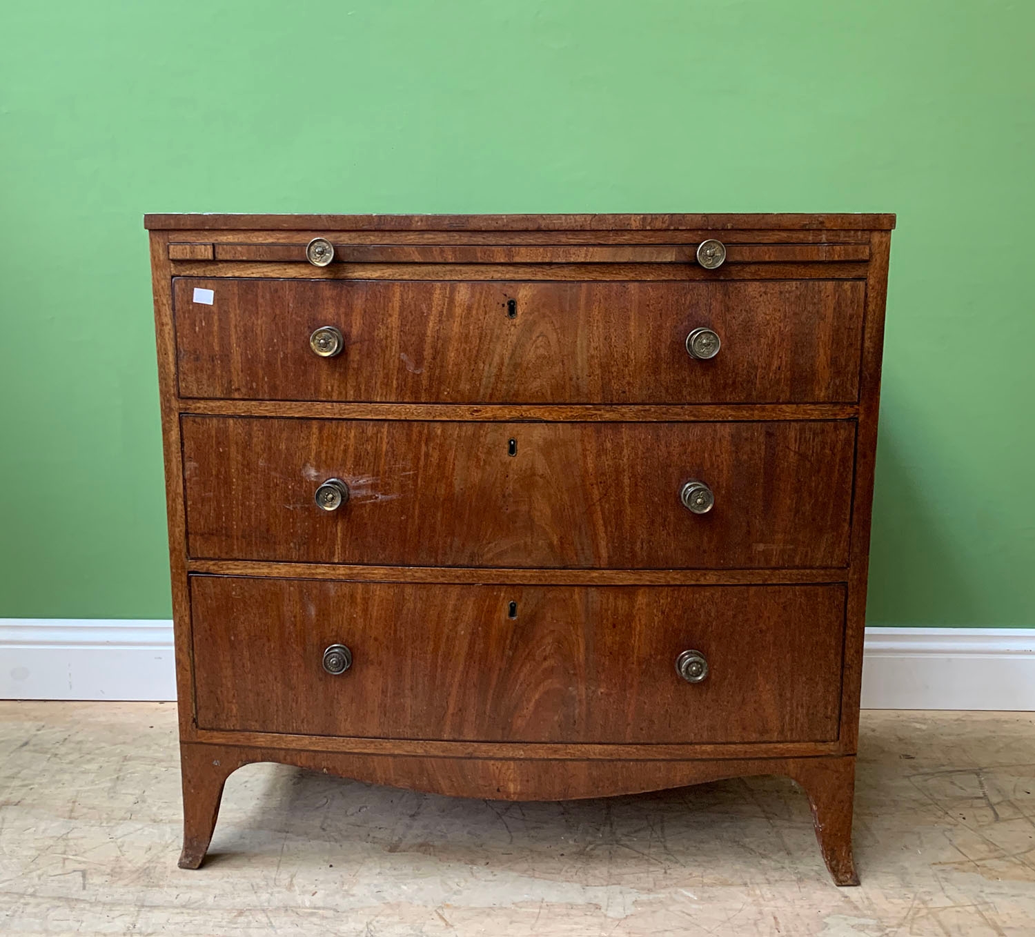 An early 19th century bowfront mahogany chest with a slide over three ...
