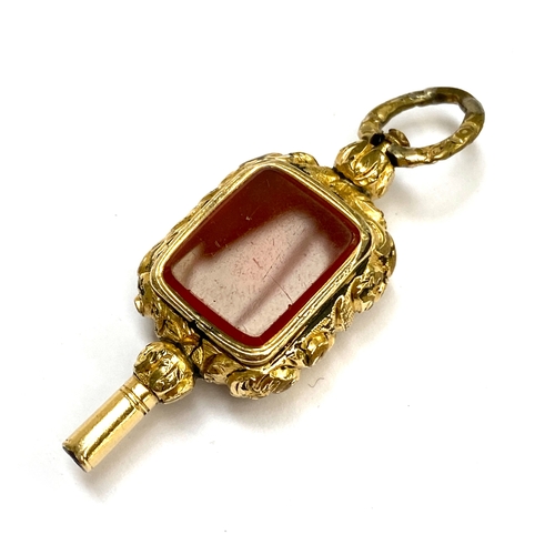 23 - A Georgian gold cased watch key, one side set with carnelian, the other with a foiled amethyst, 4.7c... 