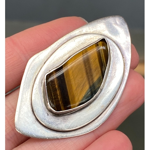 59 - A silver Modernist brooch set with tigers eye, 5.3cmL, stamped 'silver', 19.8g