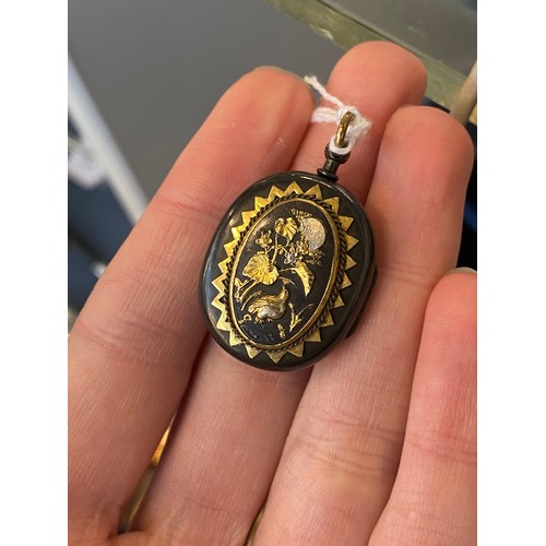 52 - A 19th century Japanese Shakudo locket, with applied silver and gold decoration, one side depicting ... 