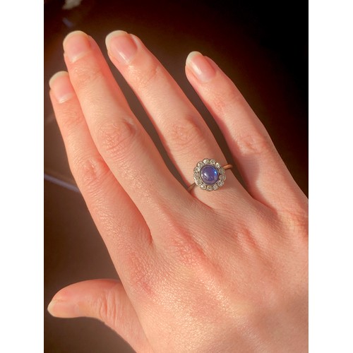 24 - An early 20th century 18ct gold, sapphire cabochon and diamond cluster ring, the sapphire measuring ... 