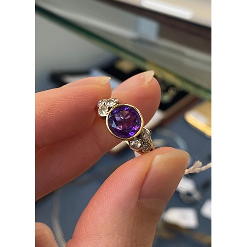 10 - An early 20th century 18ct gold, amethyst and diamond ring, the bezel mounted central stone 8mm wide... 