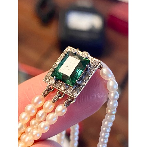 33 - An Edwardian three strand seed pearl bracelet with central rectangular bluish-green tourmaline surro... 