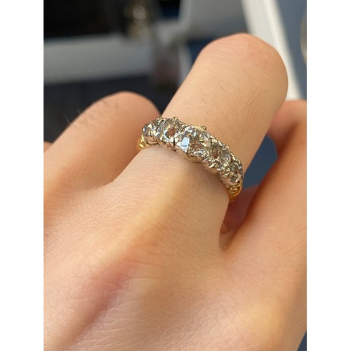 25 - A Victorian 18ct gold and diamond five stone ring, the open backed diamonds in cut down silver colle... 