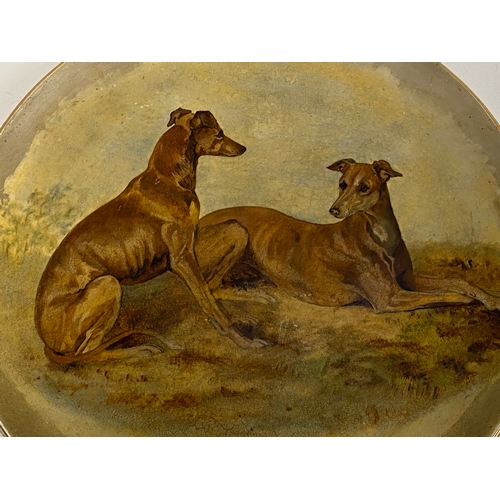 205 - Two early 20th century chargers hand painted with whippets and beagles, 36cmD