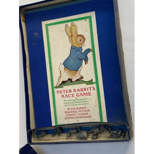 445 - An early 20th century Peter Rabbit's Race Game, boxed, with fold-out board and cast metal character ... 