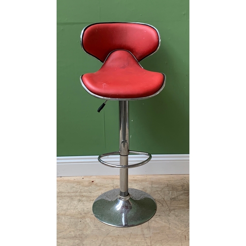 1011 - A vintage chrome and red vinyl upholstered swivel bar stool with adjustable height