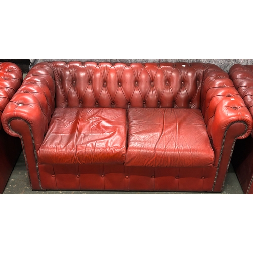 1039 - An oxblood leather button upholstered Chesterfield two seater sofa, 160x81x73cmH
