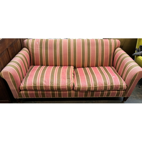 1288 - A good three seater sofa in a green and pink striped fabric, with feather filled cushions, on square... 