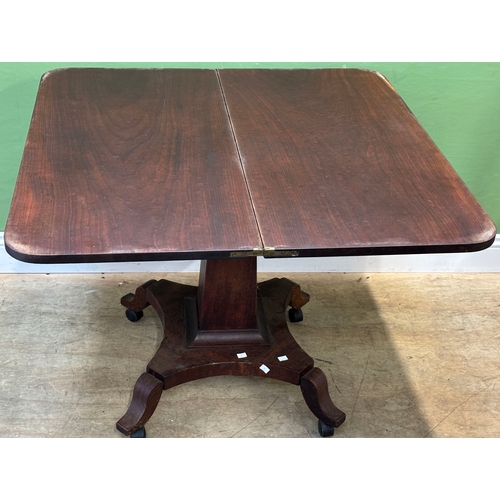 1284 - An early 19th century mahogany tea table, fold over top on tapering square column and quatrefoil bas... 