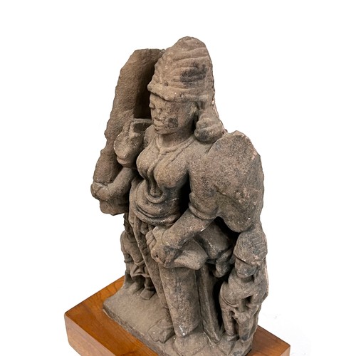 1240 - An Indian carved sandstone statue depicting the god Surya flanked by diminutive attendants, 47cmH ex... 