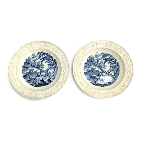 260 - A pair of 19th century pearlware plates depicting shepherds playing pipes, with foliate borders, 18c... 