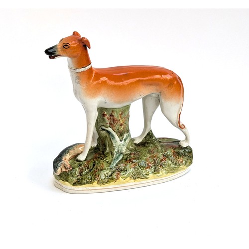 289 - A 19th century Staffordshire long dog on a naturalistic base 25cmH