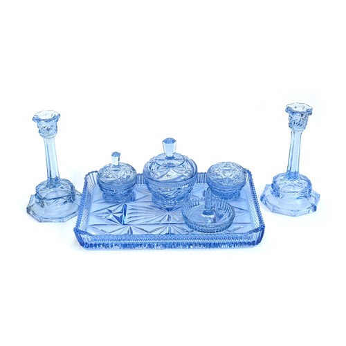 285 - An Art Deco light blue glass dressing table set to include: pair of candlesticks, pots, etc