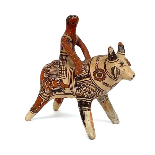276 - A Mexican folk art terracotta figure of bull and rider, 22cmH