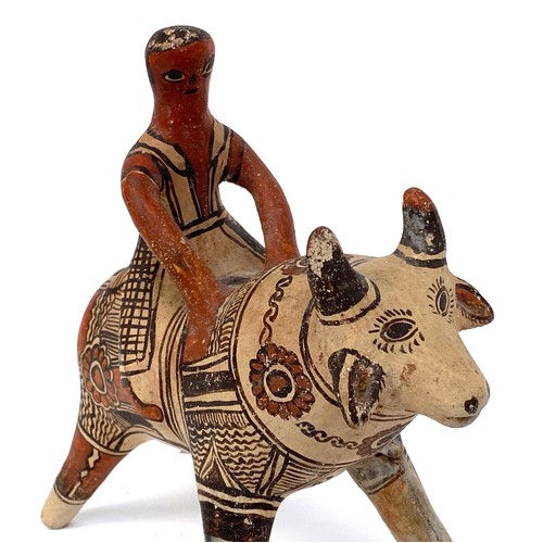 276 - A Mexican folk art terracotta figure of bull and rider, 22cmH