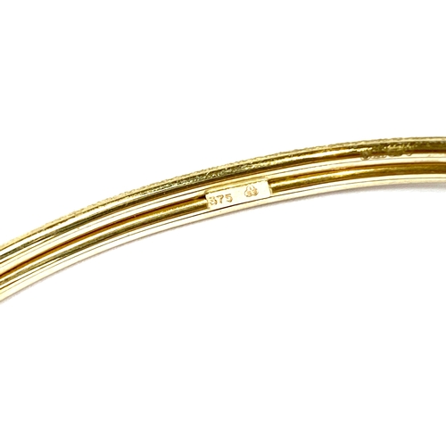 25 - A 9ct gold and CZ crossover bangle, 6.5cmW internal width, 6.5g