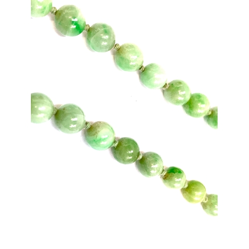 42 - An early 20th century jade bead necklace, the beads graduated and knotted, ranging from 3mm to 7mm, ... 