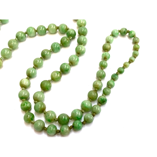 42 - An early 20th century jade bead necklace, the beads graduated and knotted, ranging from 3mm to 7mm, ... 