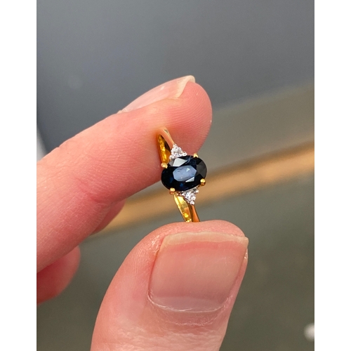 20 - An 18ct gold sapphire trilogy ring, the sapphire 7.1x5.3mm, size K 1/2, 2.2g