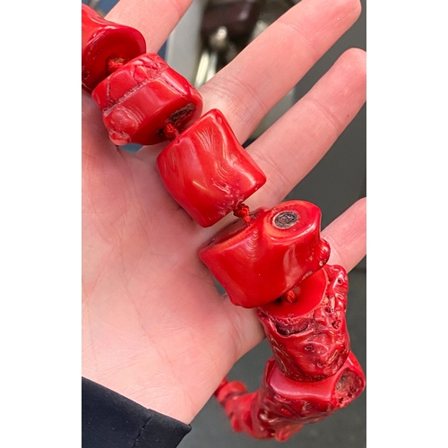 32 - A vintage chunky red coral necklace, knotted, the largest bead 2.5cmL, 55cmL unclasped
