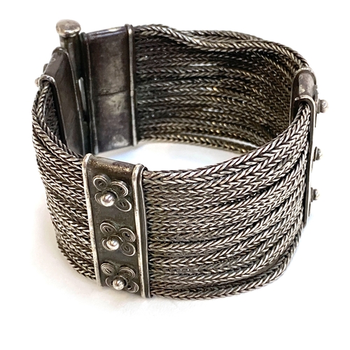 48 - An early 20th century Indian silver Rajasthani woven style bracelet with floral decoration, fastenin... 