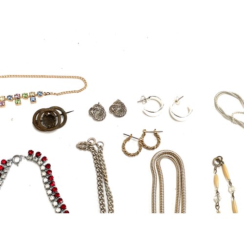 13 - A mixed lot of costume jewellery to include gold and silver tone chains, red and white paste necklac... 