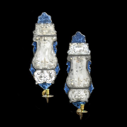 A pair of Anglo-Dutch blue glass and mirrored girandoles, c.1690 and later, with lead-framed shaped bevelled backplates surrounded by floral engraved blue glass panels, with later brass sconces, each 19cm wide, 51cm high