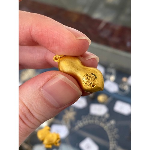 11 - Two Chinese 24ct gold pendants, one in the form of a peanut, gross weight 6g
