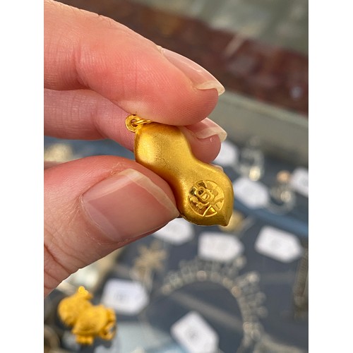 11 - Two Chinese 24ct gold pendants, one in the form of a peanut, gross weight 6g
