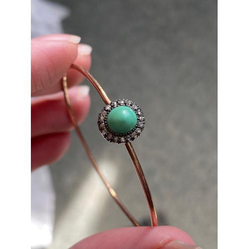 12 - A Victorian gold wire bangle set with a silver mounted turquoise cabochon and diamond cluster, the b... 