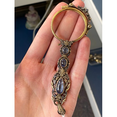 32 - A pair of 19th century gold and silver lorgnettes, of pierced foliate form, bezel set with three sap... 