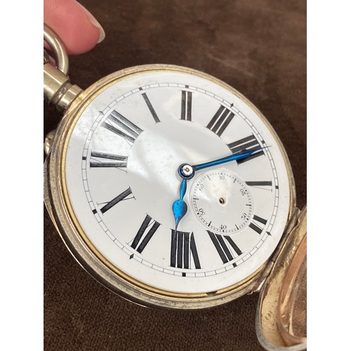 38 - A plated Goliath pocket watch, 6.2cm diameter, with a silver case, c.1900, 12cm high