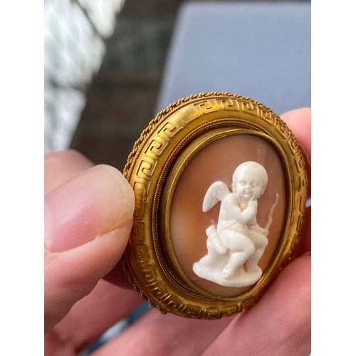 19 - A Victorian gold mounted carved shell cameo brooch depicting cupid seated, 4cm long, 8.3g; together ... 