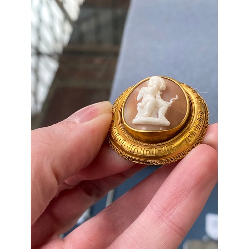 19 - A Victorian gold mounted carved shell cameo brooch depicting cupid seated, 4cm long, 8.3g; together ... 