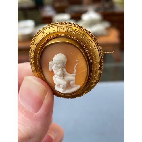 19 - A Victorian gold mounted carved shell cameo brooch depicting cupid seated, 4cm long, 8.3g; together ... 