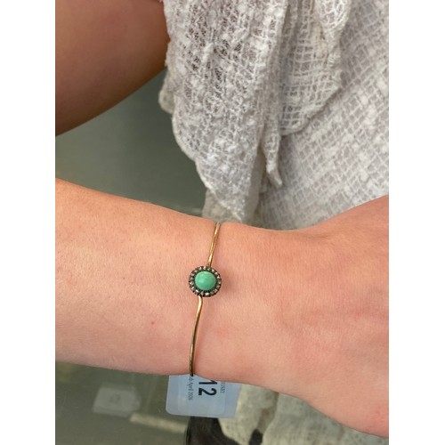 12 - A Victorian gold wire bangle set with a silver mounted turquoise cabochon and diamond cluster, the b... 
