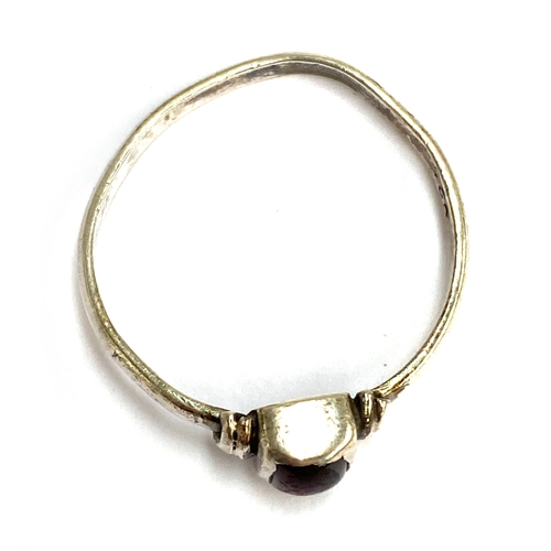 107 - A Medieval style silver ring set with a garnet cabochon in a rubover setting, size Q, 1.4g