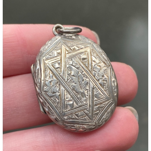 40 - A Victorian silver engraved oval locket, one side decorated with a star, the other foliate, 3.2cmL, ... 