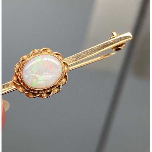 9 - A 9ct gold and opal bar brooch, the opal 10x7.5mm, the brooch 5cmW overall, hallmarked for London 19... 